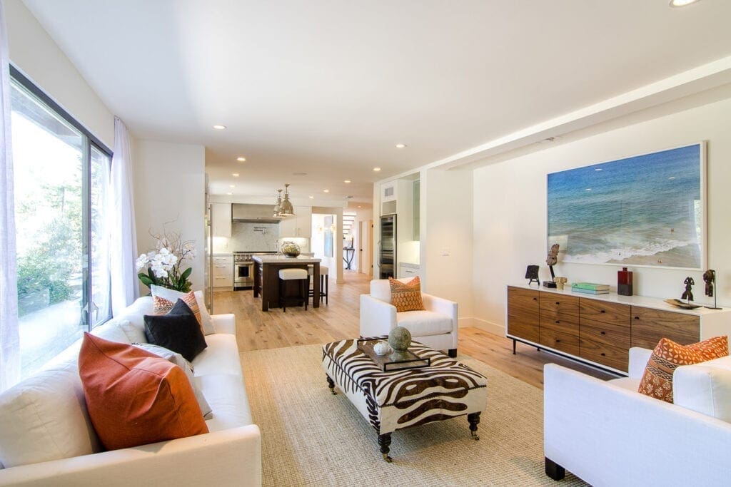 A living room with white furniture and a large rug.