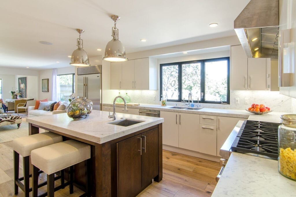 A kitchen with white cabinets and wooden floors.