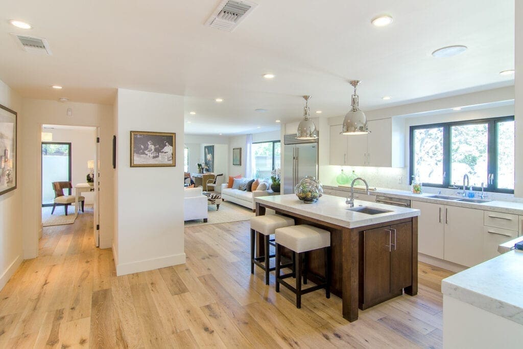 A kitchen with wood floors and white walls.