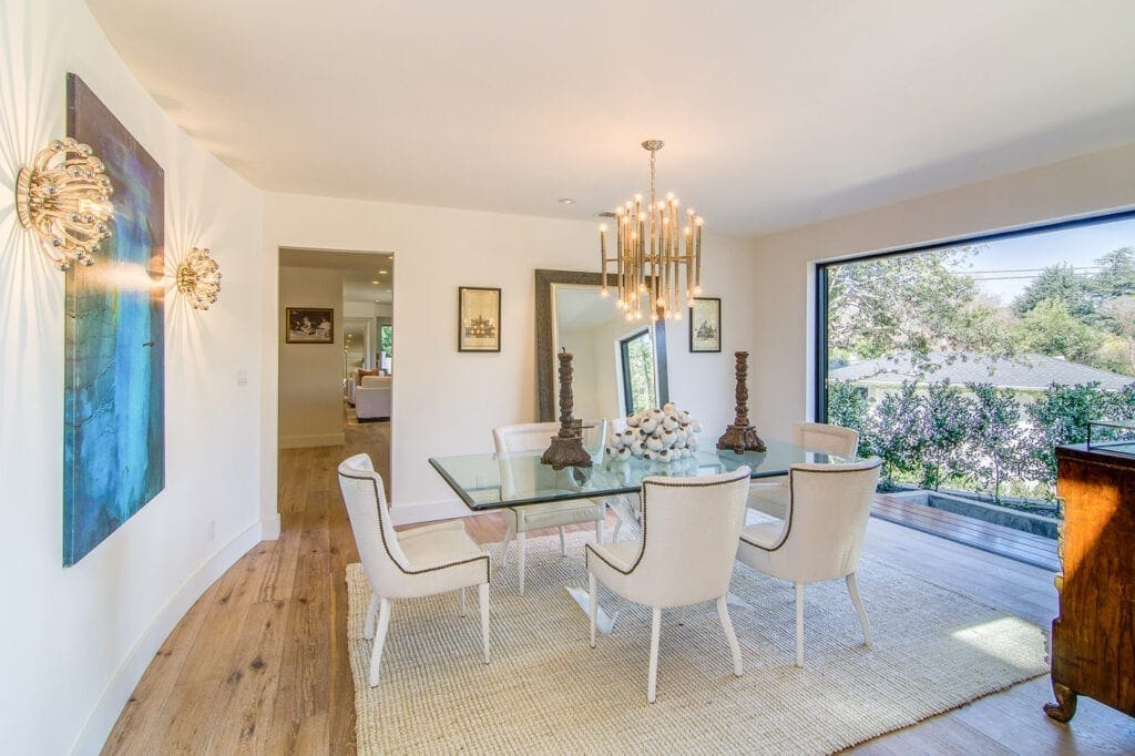 A dining room table with chairs and a chandelier.