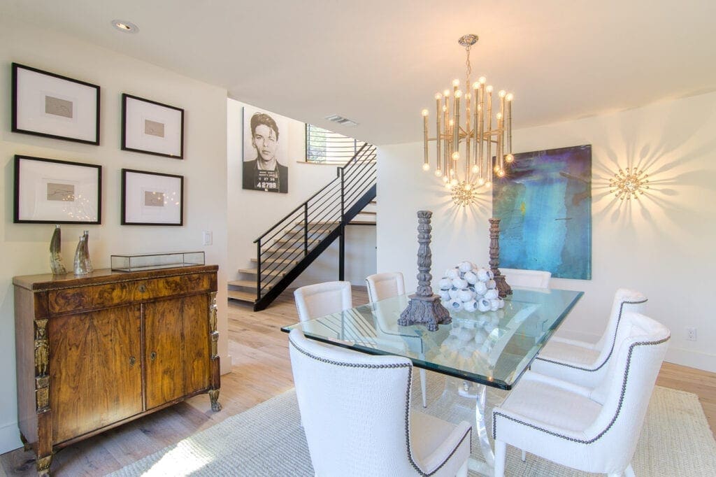 A dining room with a glass table and chandelier.