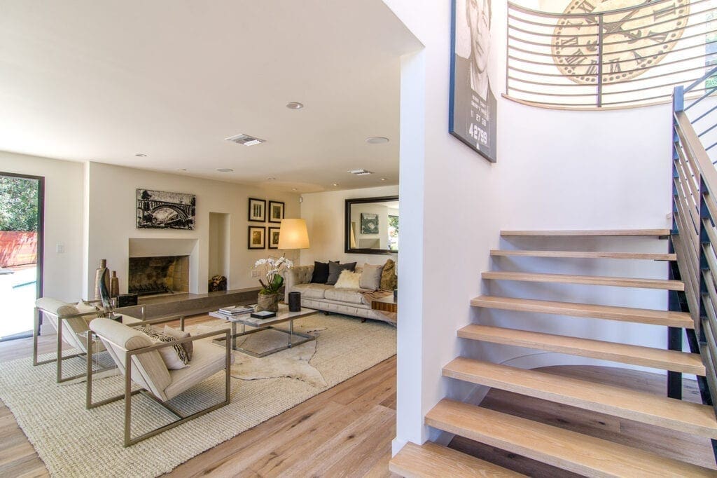 A living room with stairs leading to the second floor.