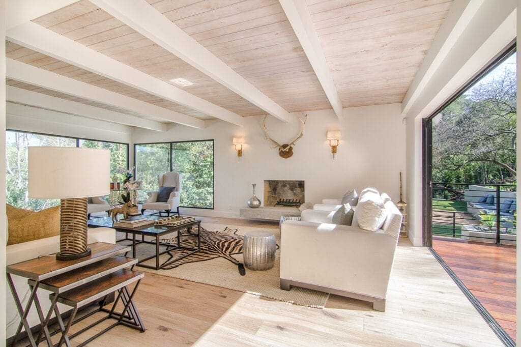 A living room with white furniture and wood floors.