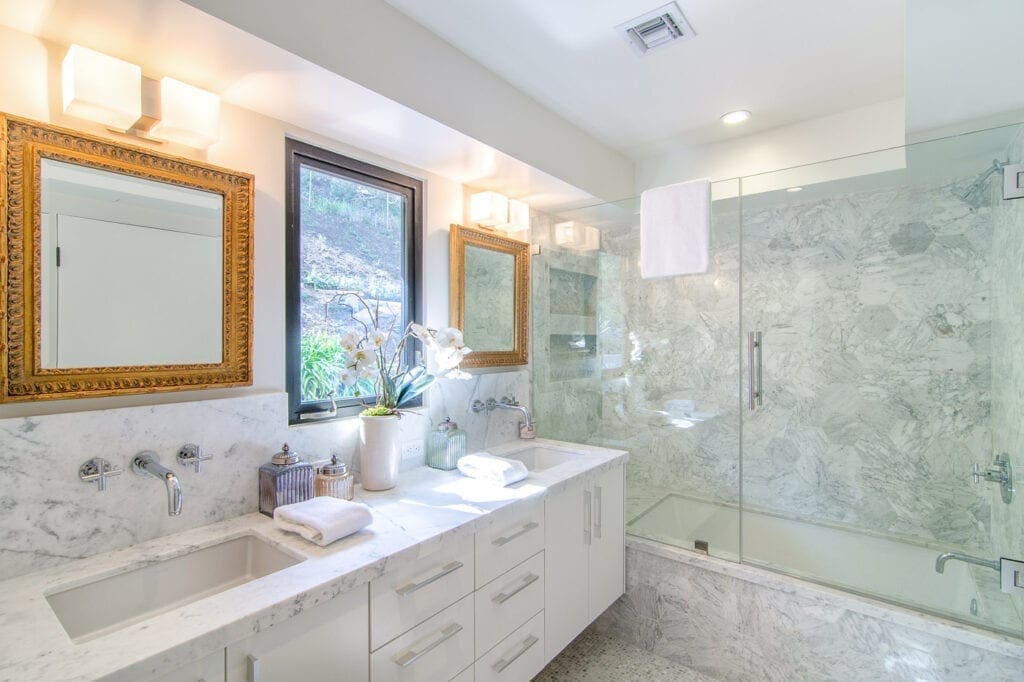 A bathroom with two sinks and a shower.