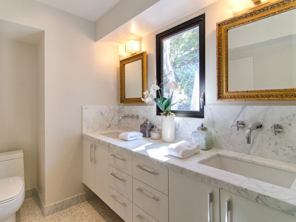 A bathroom with two sinks and mirrors in it
