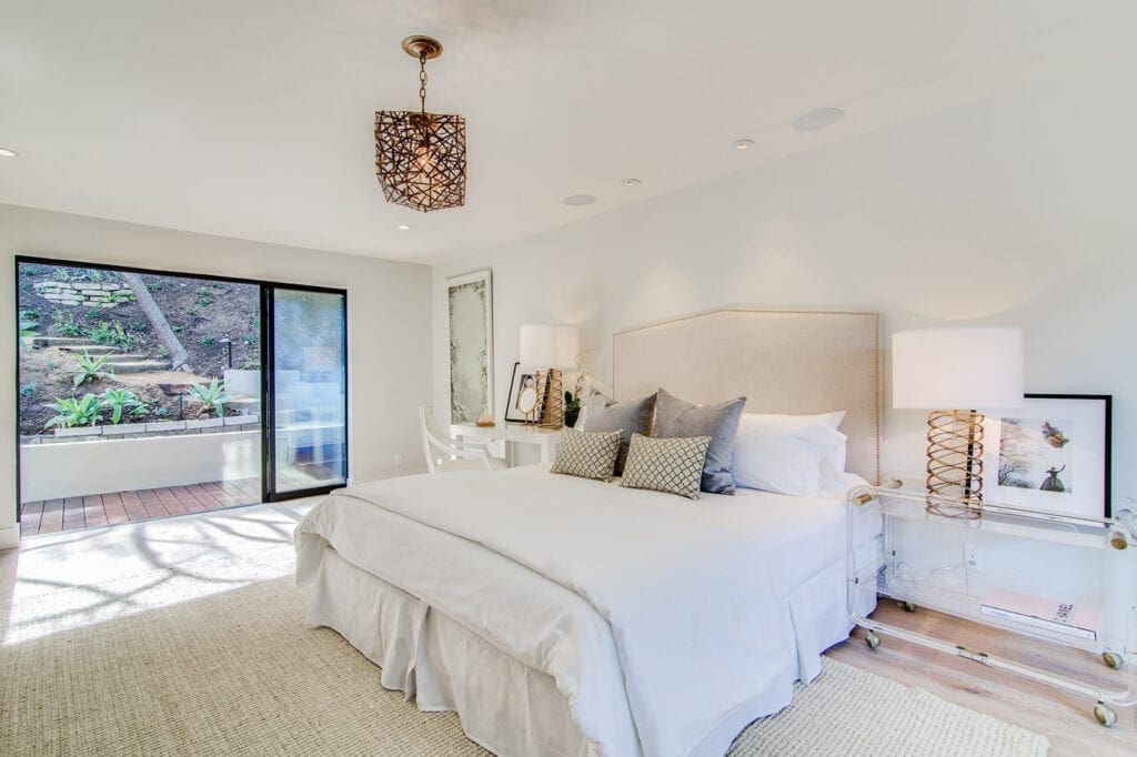 A bedroom with white walls and furniture.