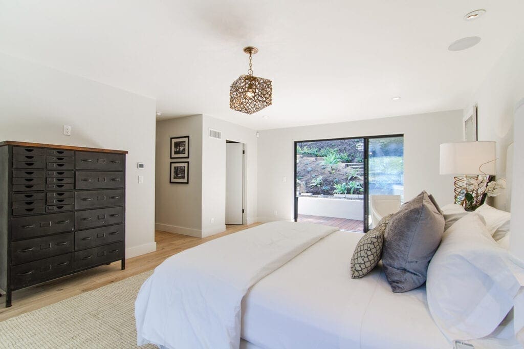 A bedroom with white walls and a large bed.