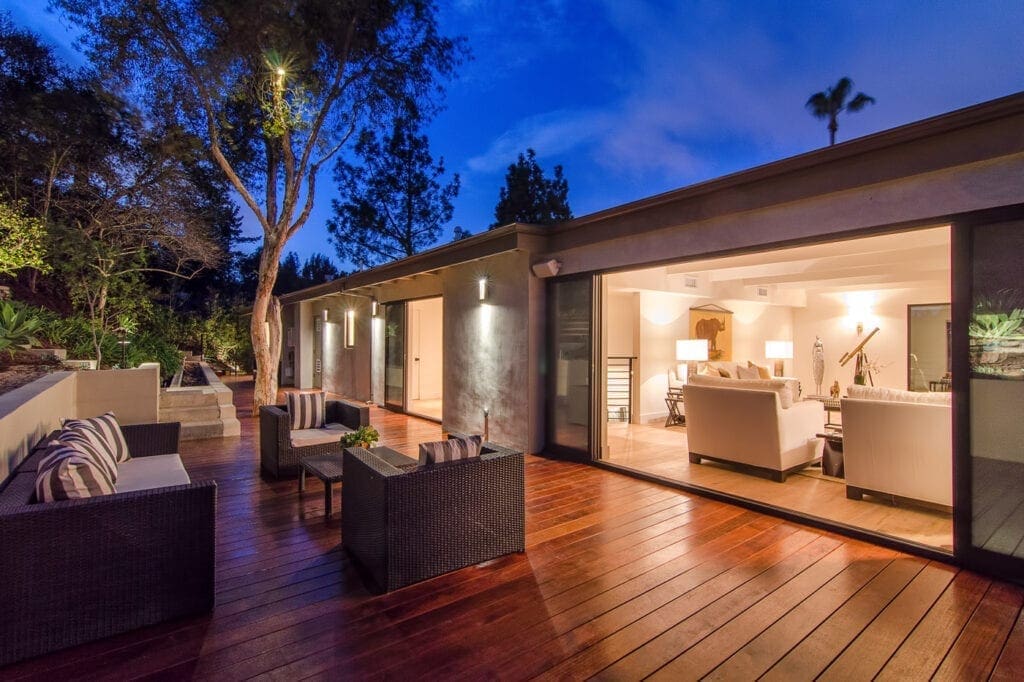 A large open patio with furniture and lights on.
