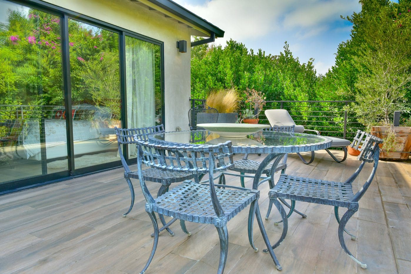 A patio with chairs and tables on top of it.