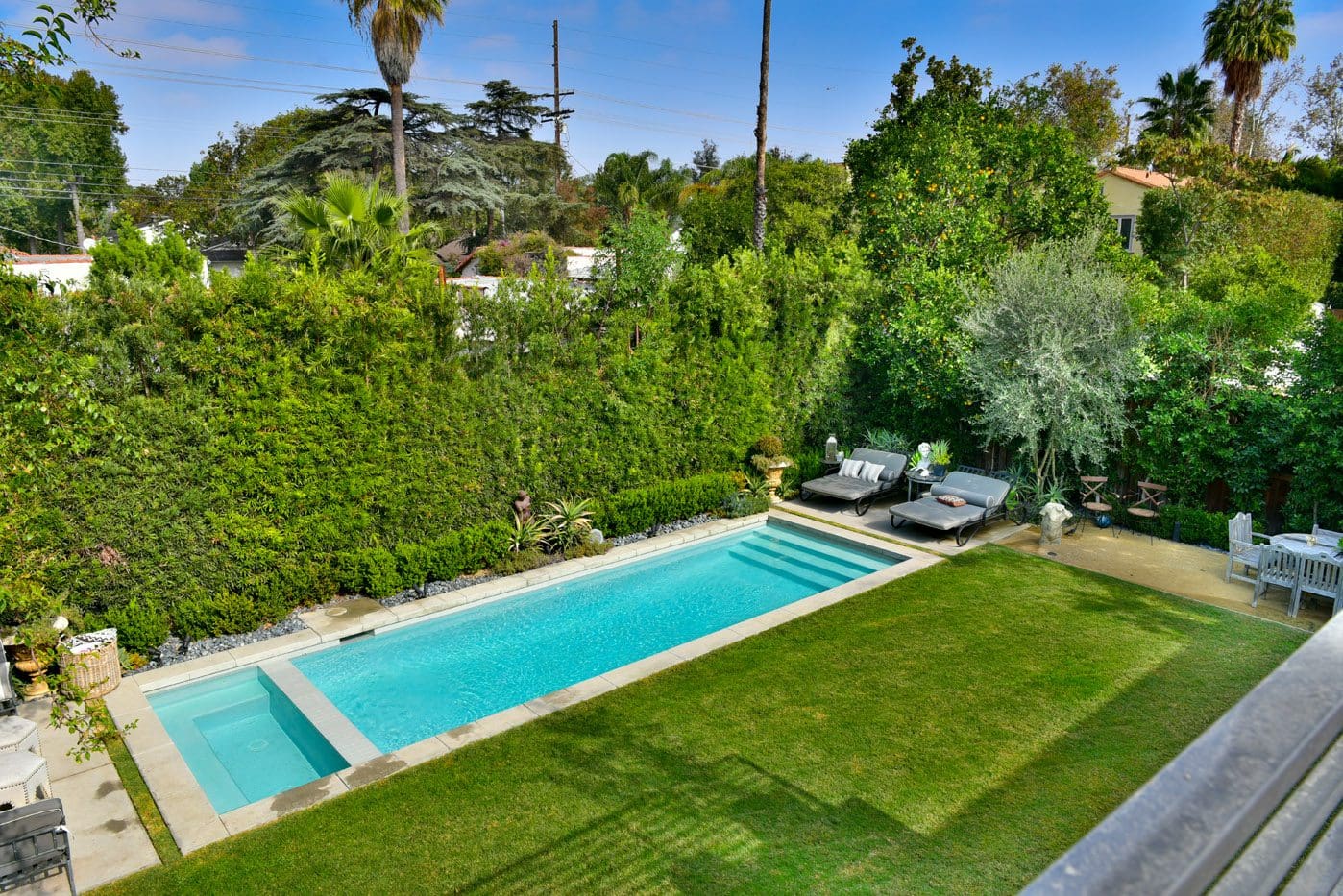 A pool with grass and trees in the background