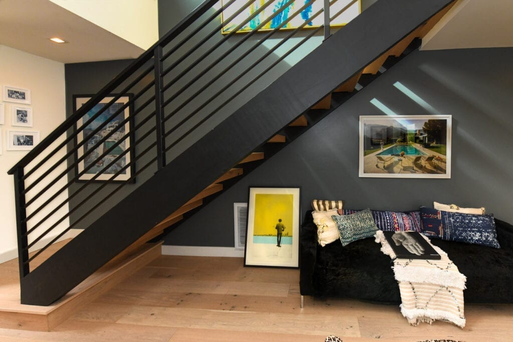 A couch and chair in front of the stairs.