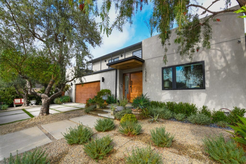 A house with a lot of plants in front of it