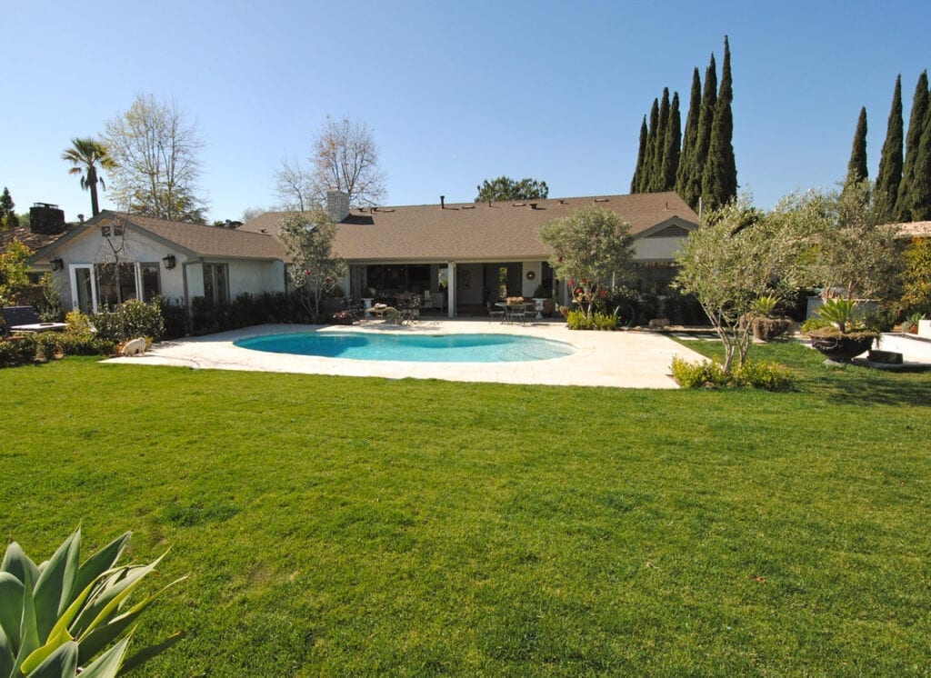 A large pool in the middle of a yard.