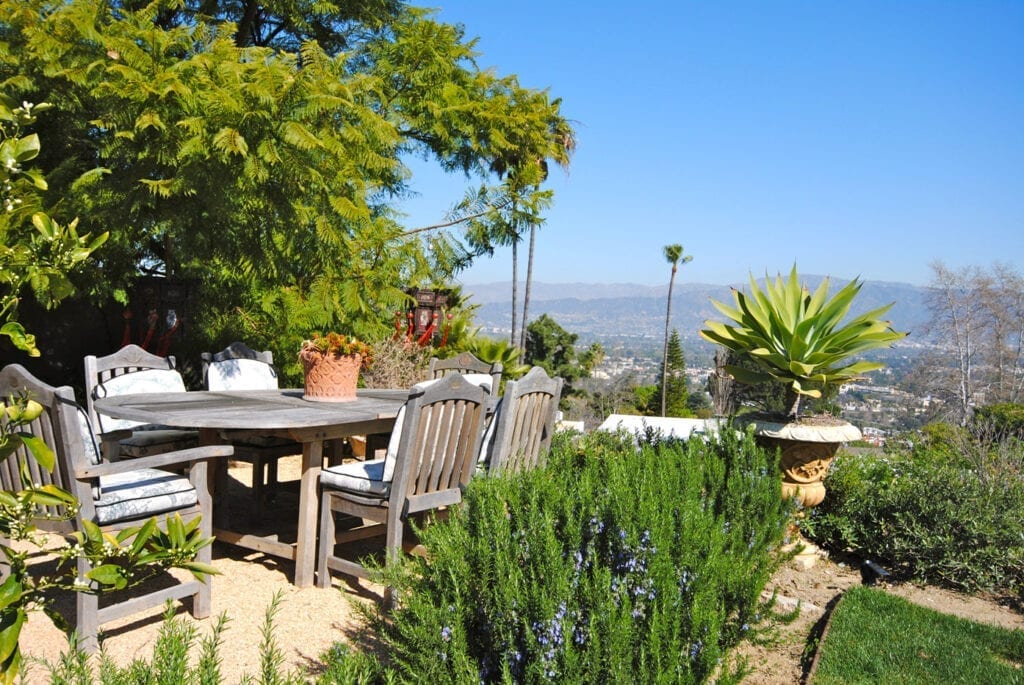 A table and chairs in the middle of an outdoor garden.