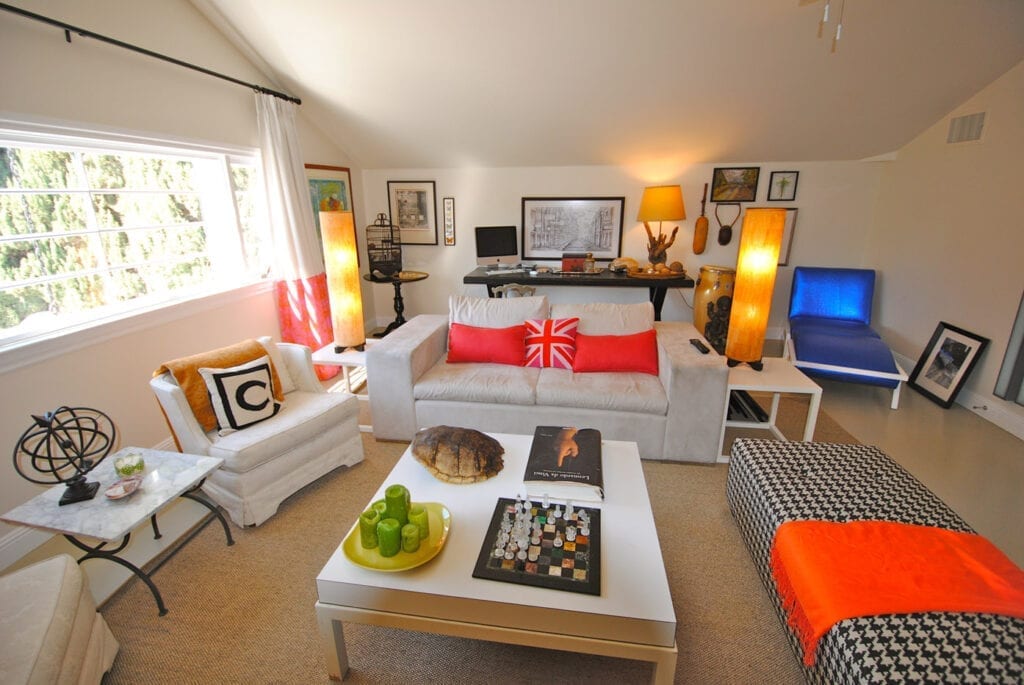 A living room with couches, tables and a television.