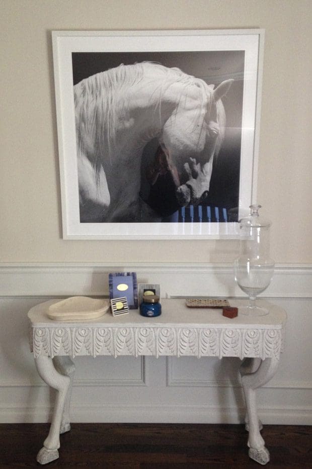 A white table with a picture on the wall