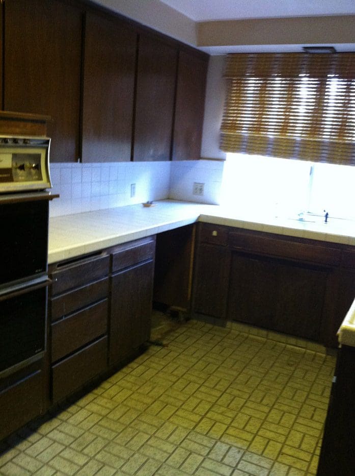 A kitchen with brown cabinets and yellow floor