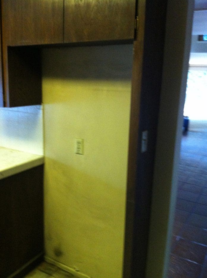 A yellow door in the kitchen of an apartment.