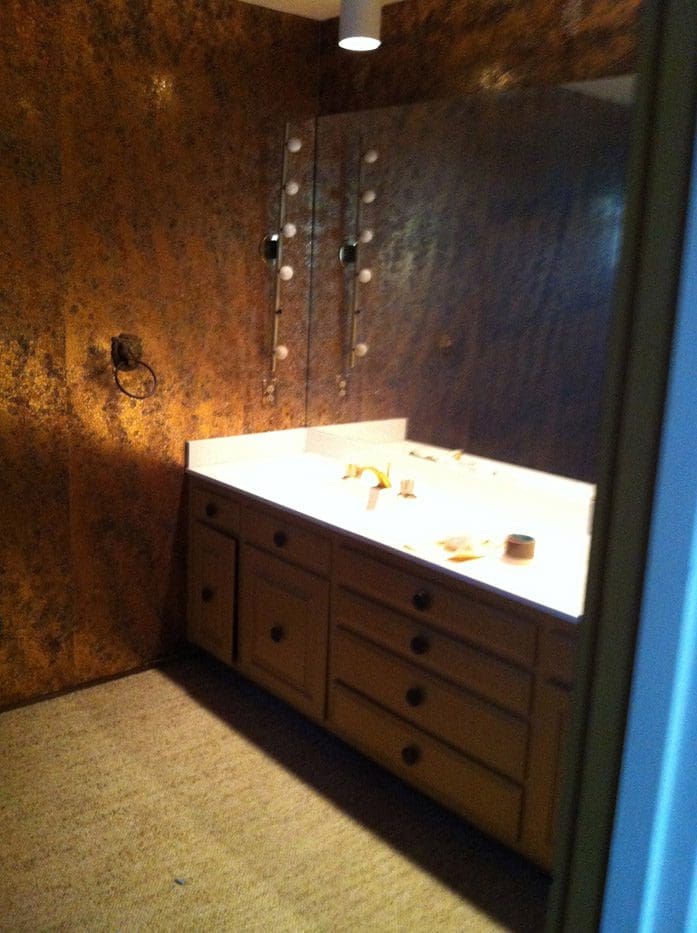 A bathroom with wood paneling and a sink.
