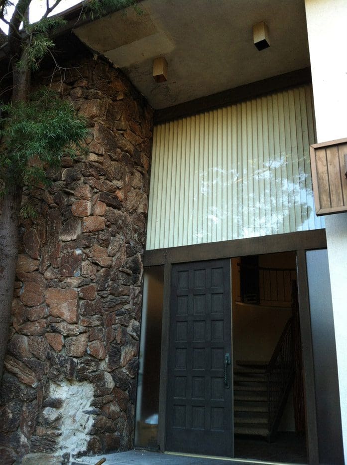A building with a large wall and wooden door.