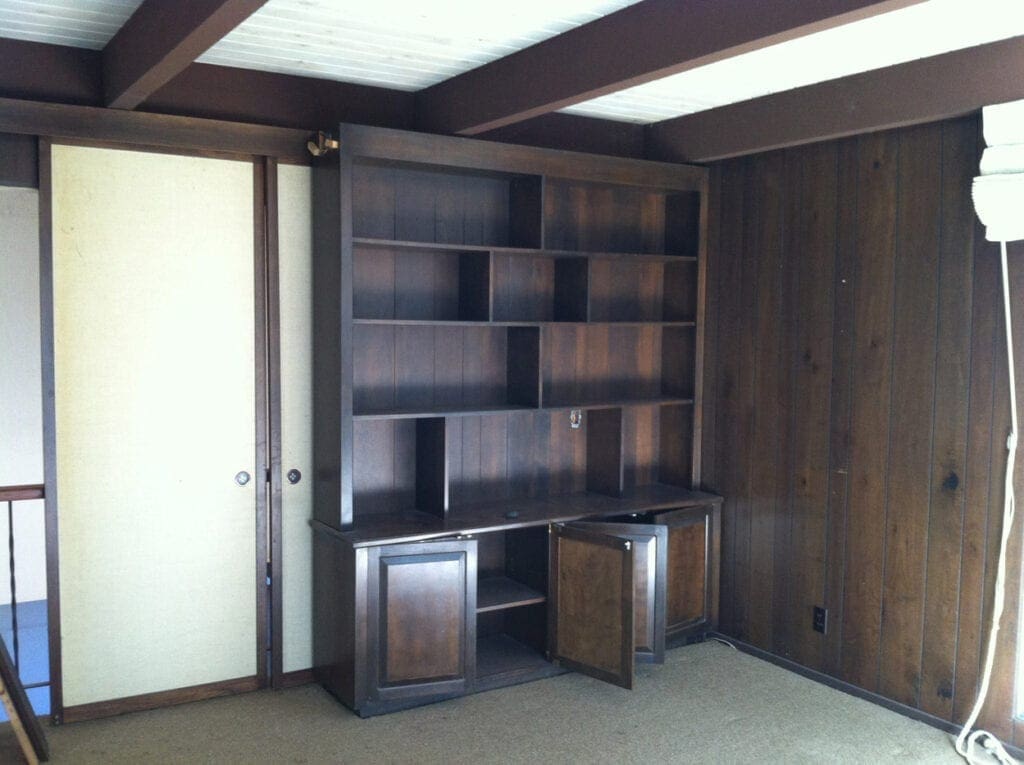 A room with a large wooden bookcase and two metal cabinets.