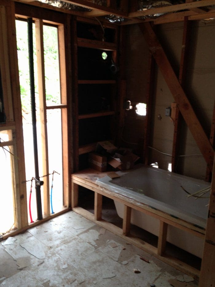 A bathroom with a tub and bench in it