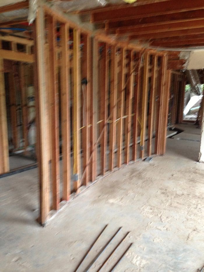 A room with wood framing and a wall.