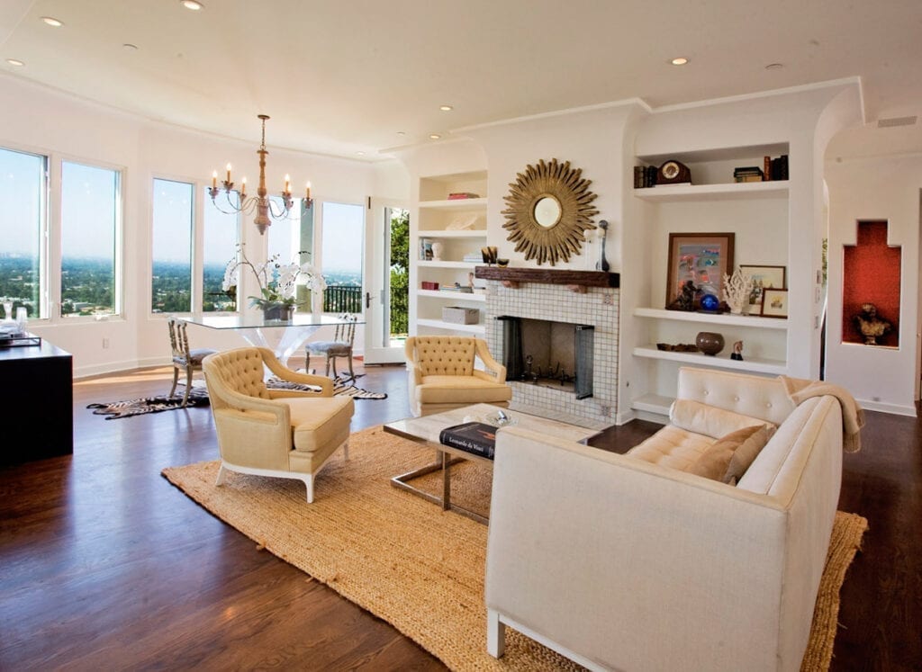 A living room with white furniture and wood floors.