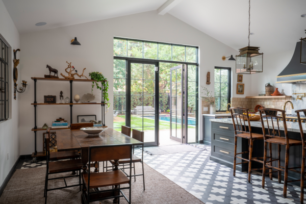 A dining room with a table and chairs, and sliding glass doors.