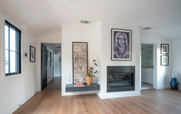 A living room with a fireplace and a painting on the wall.