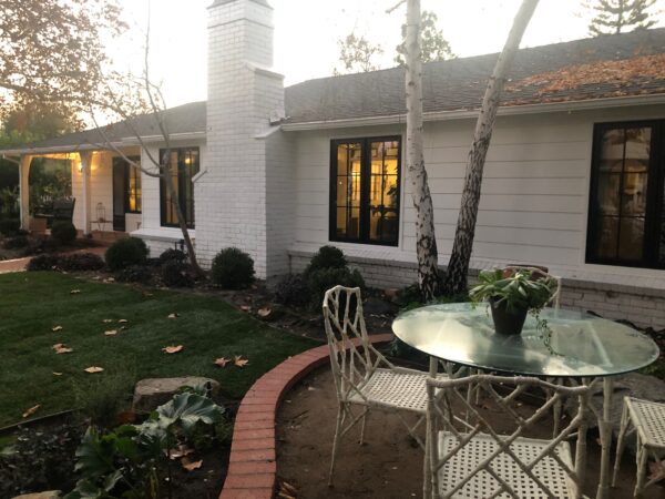 A white house with a brick walkway and patio.