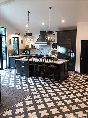 A kitchen with black and white tile floor