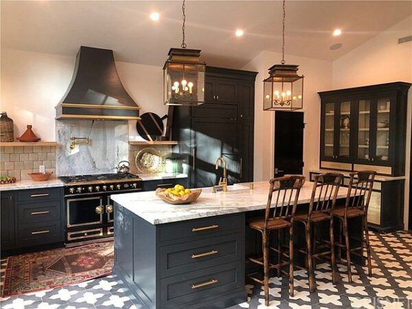 A kitchen with a large island and black cabinets.