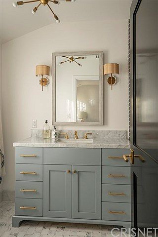 A bathroom with a sink and mirror in it