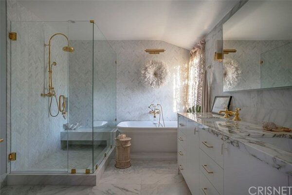 A bathroom with a tub, shower and sink.