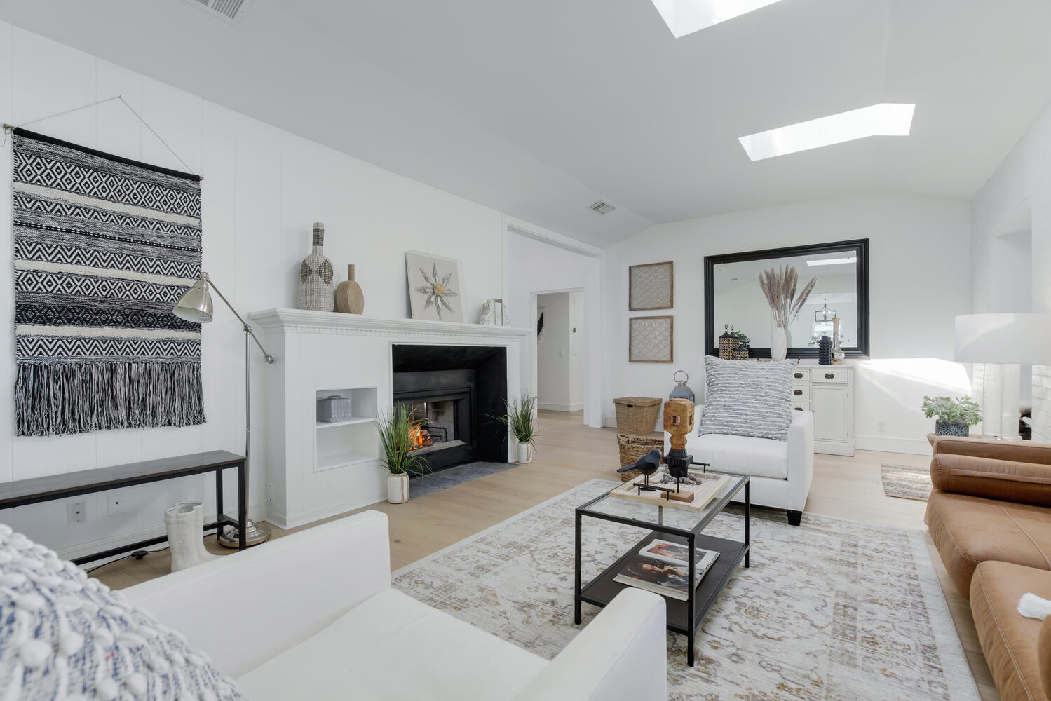 A living room with white furniture and fireplace.