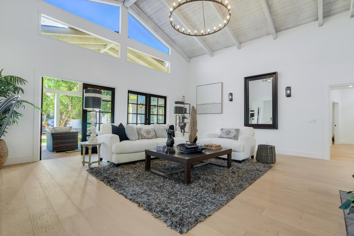 A living room with a large window and a rug.