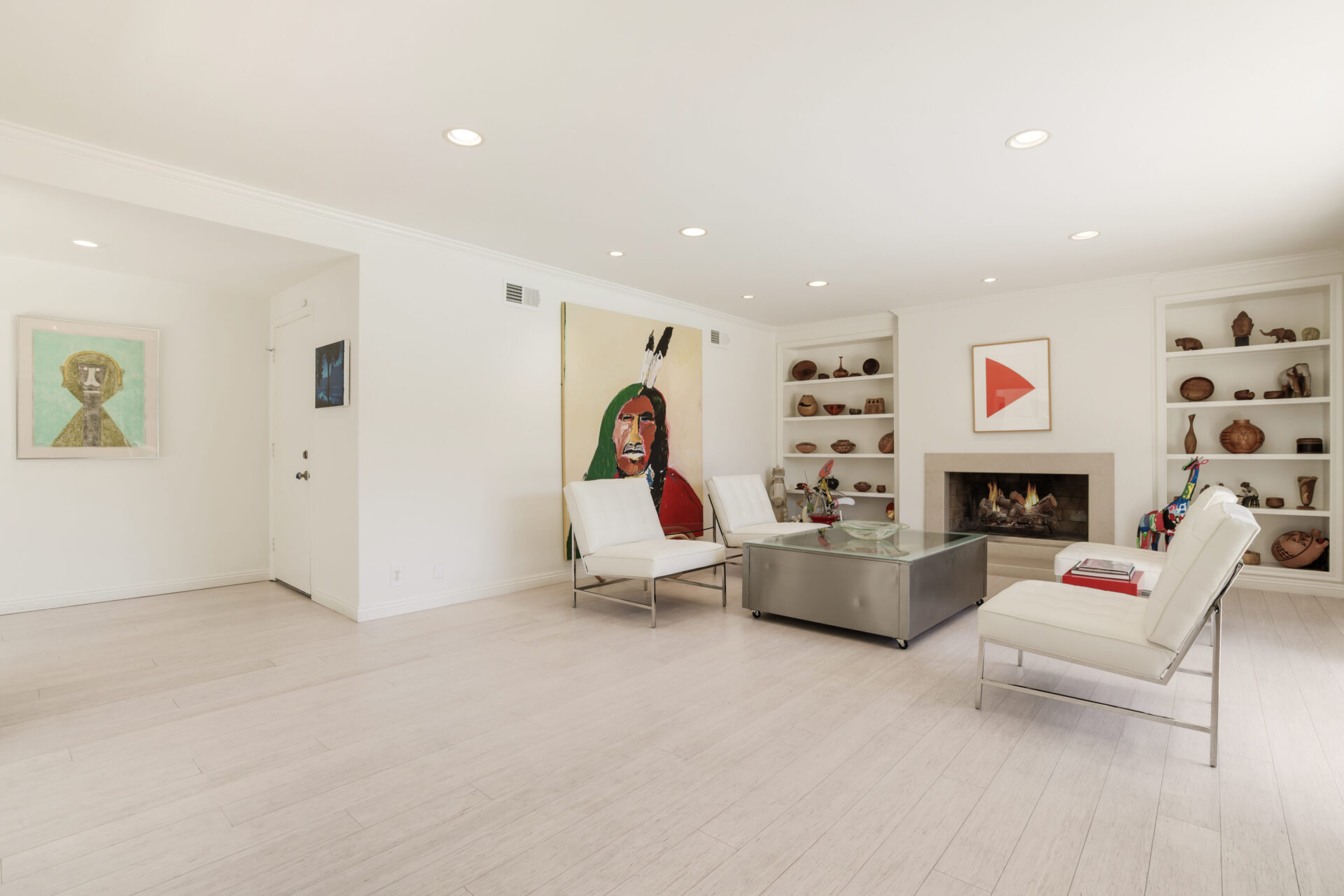 A living room with white furniture and a fireplace.