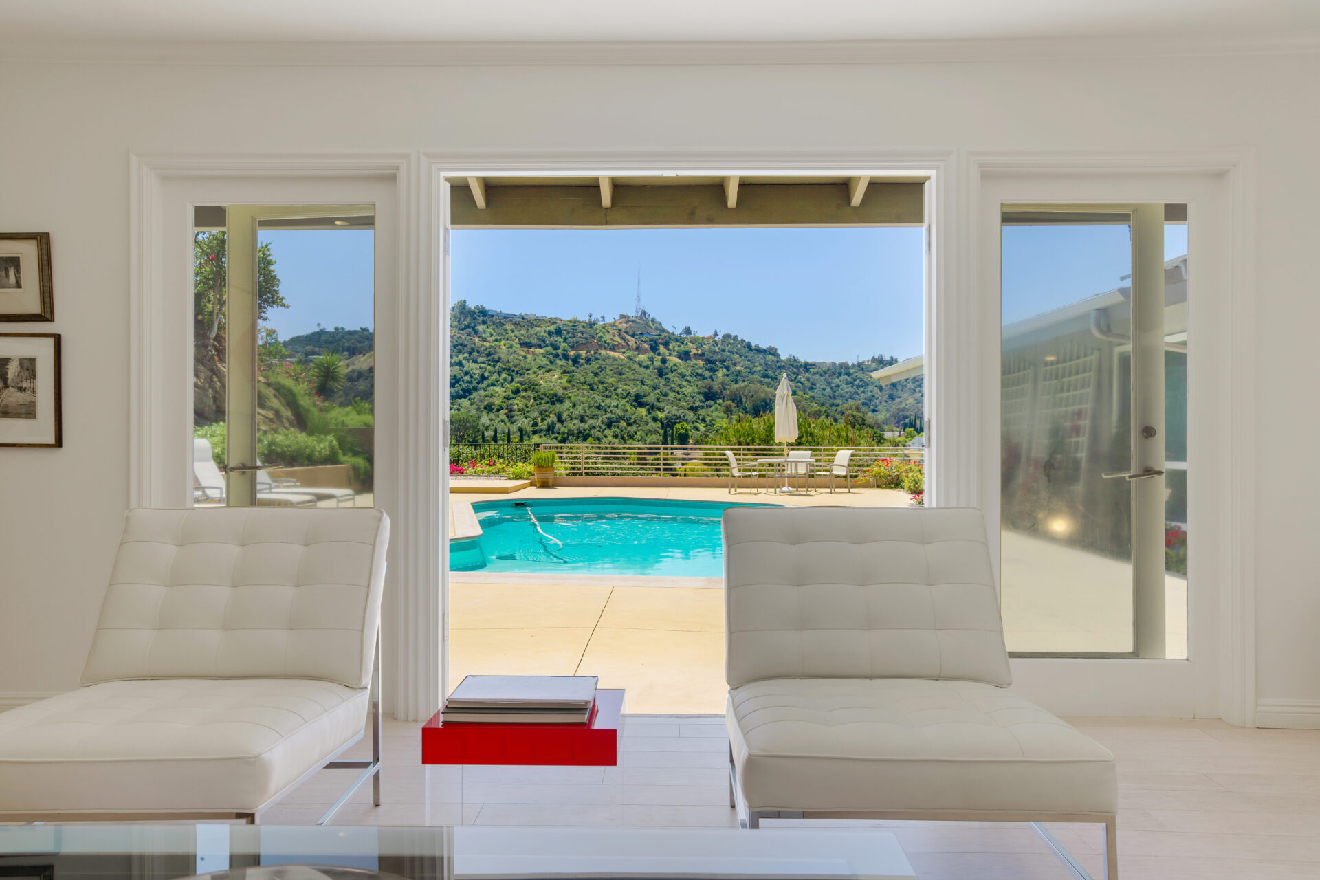 A room with two white chairs and a pool