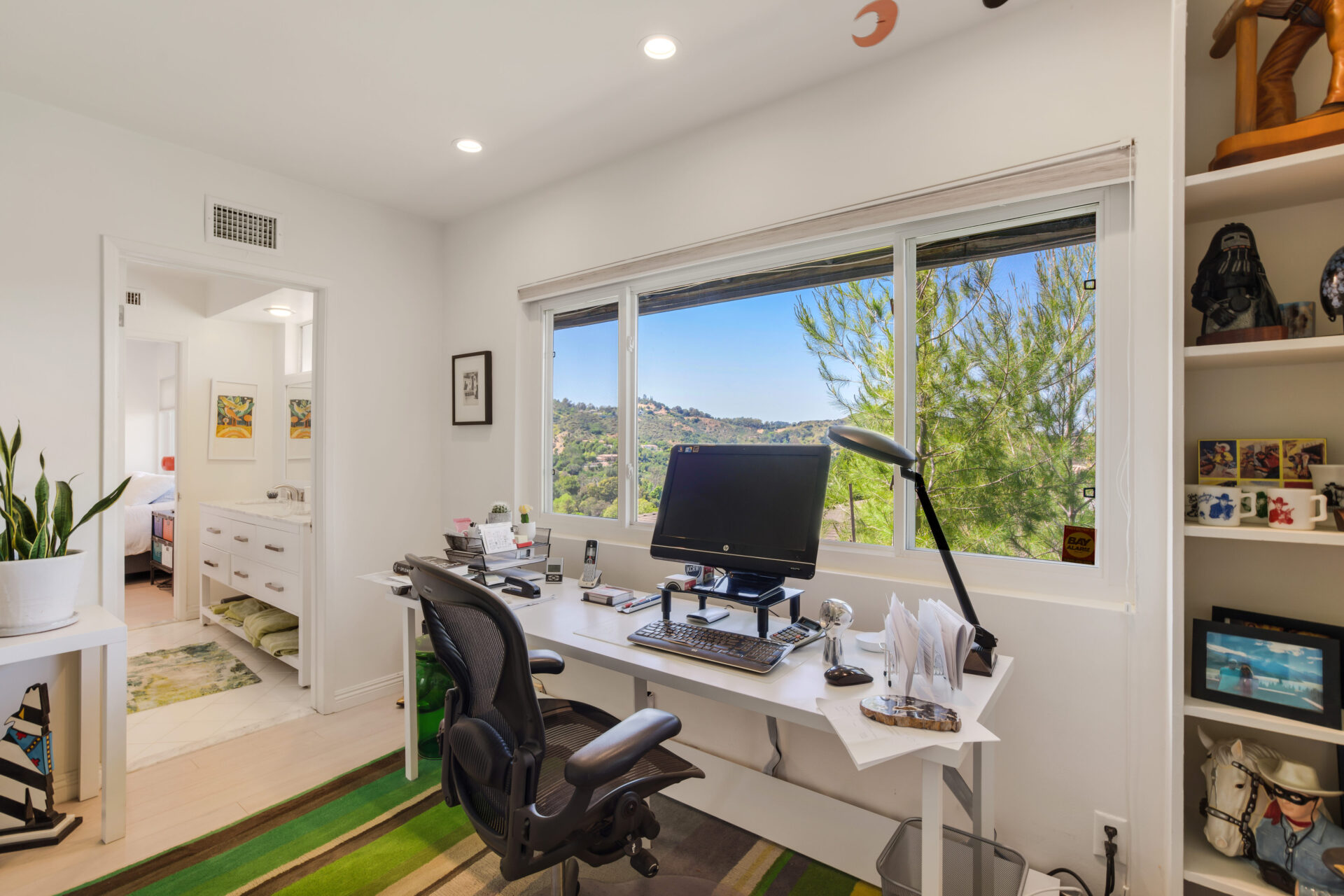 A desk with a computer and chair in front of a window.