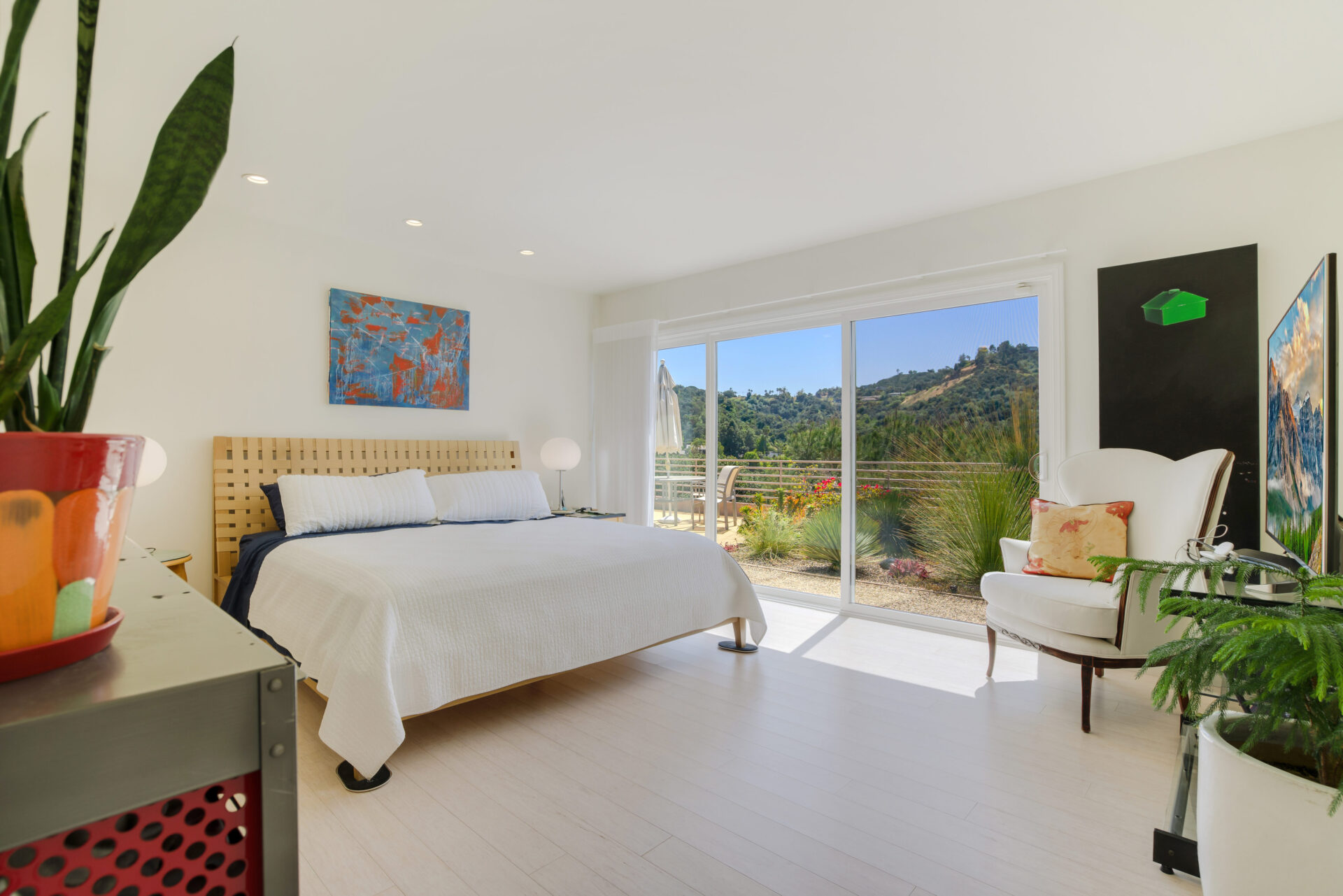 A bedroom with a large bed and sliding glass doors.