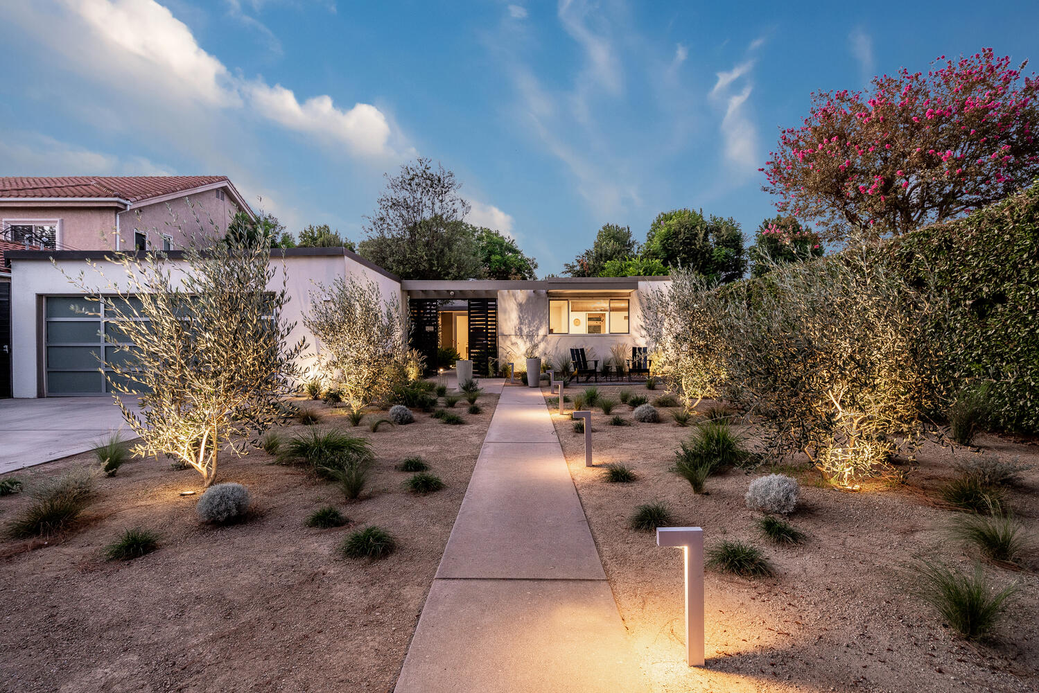 A walkway with lights and plants in the middle of it.