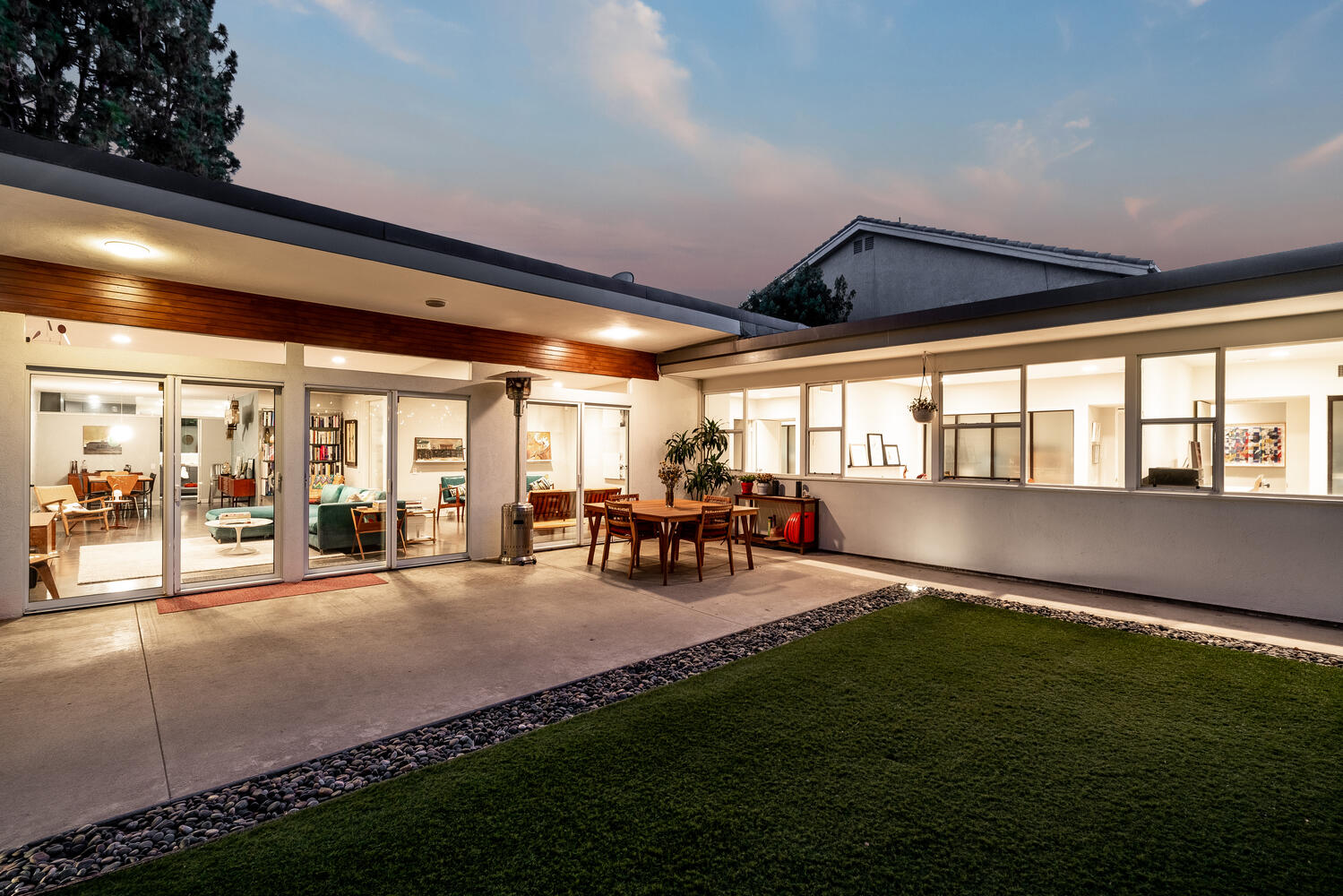 A large patio with grass and lawn in the evening.