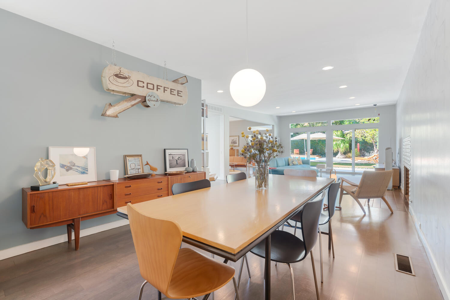 A dining room table with chairs and a wall clock.