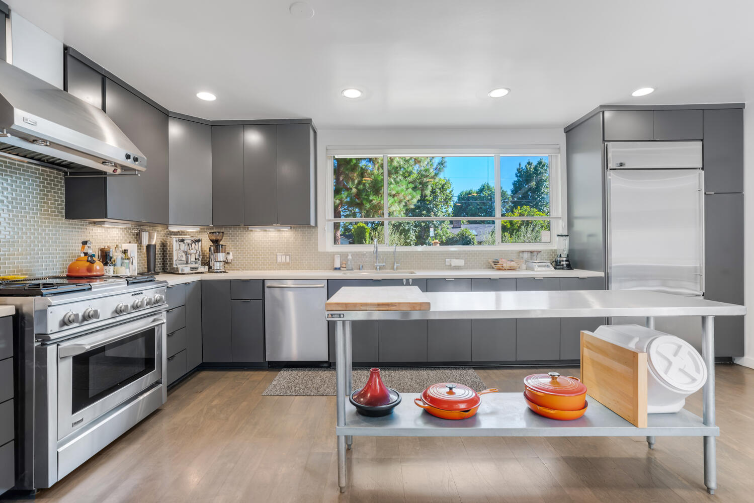 A kitchen with stainless steel appliances and grey cabinets.