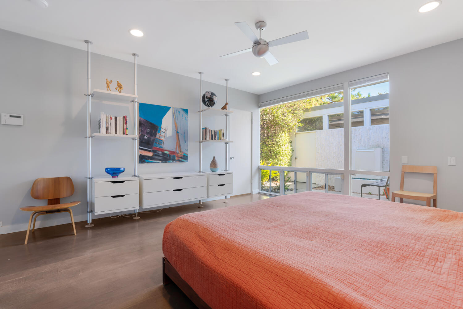 A bedroom with a bed, desk and window.