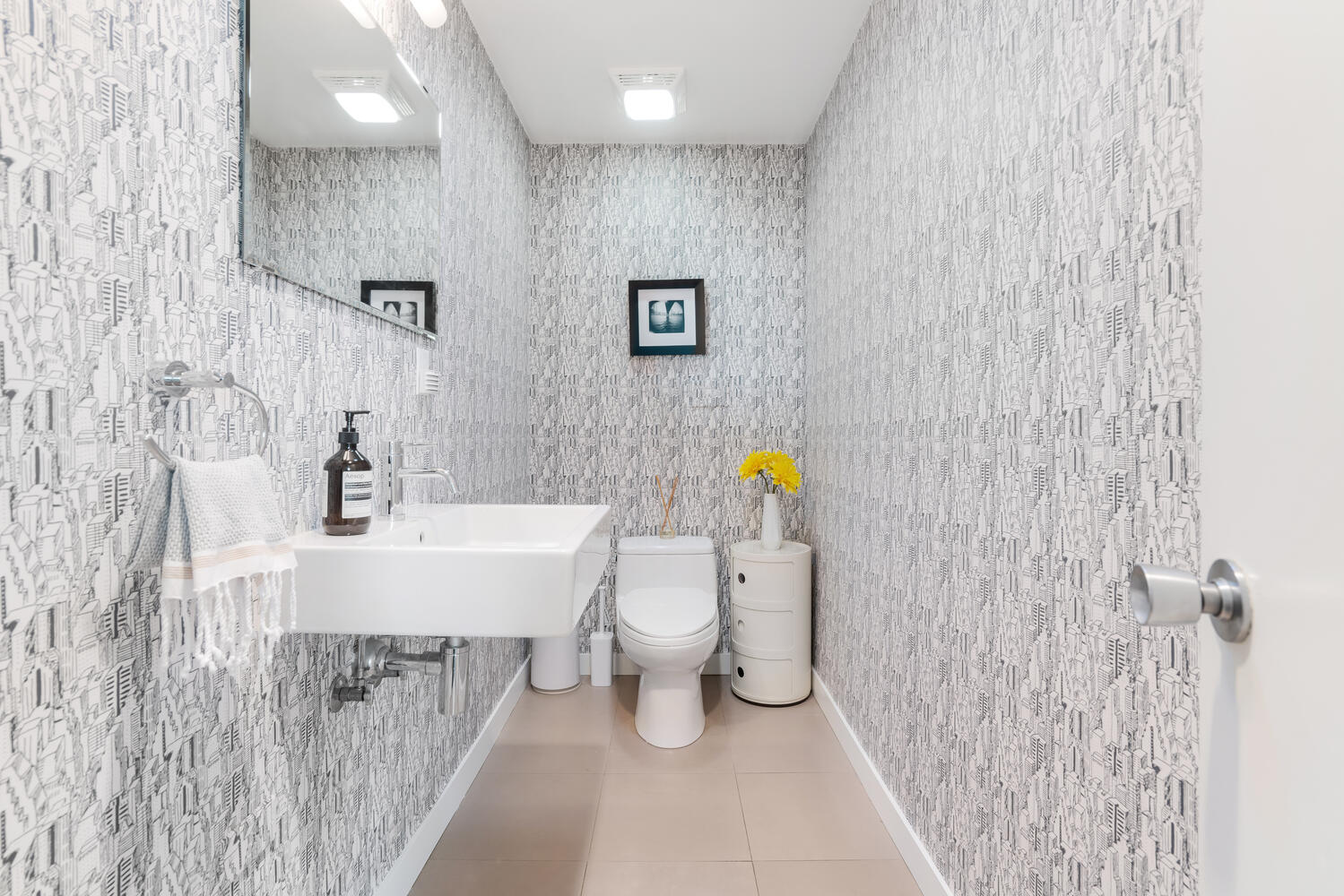 A bathroom with white walls and tile floors.