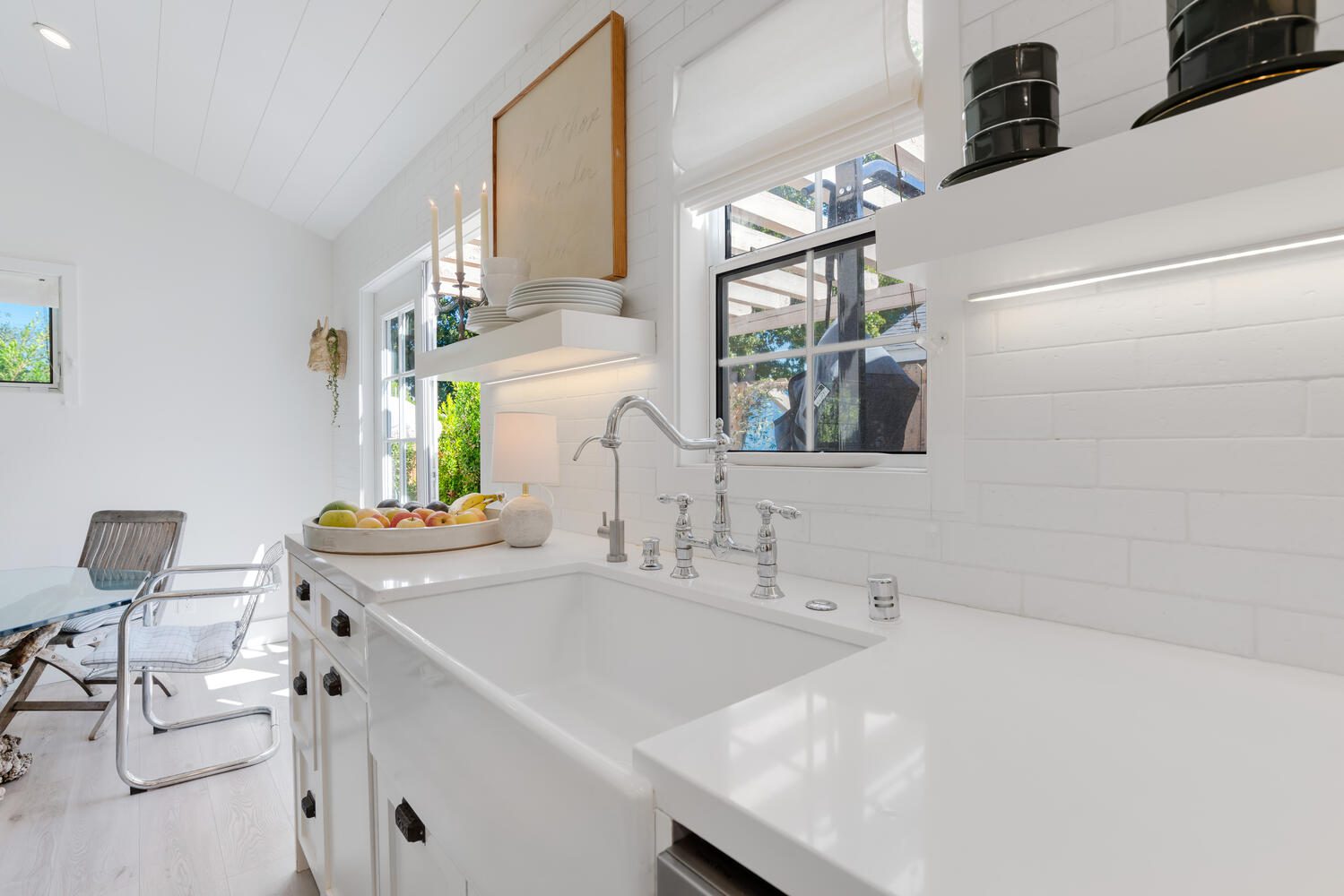 A white kitchen with a sink and mirror