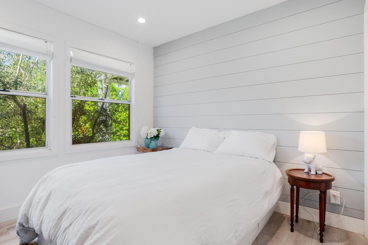 A bed room with a white bed and a window