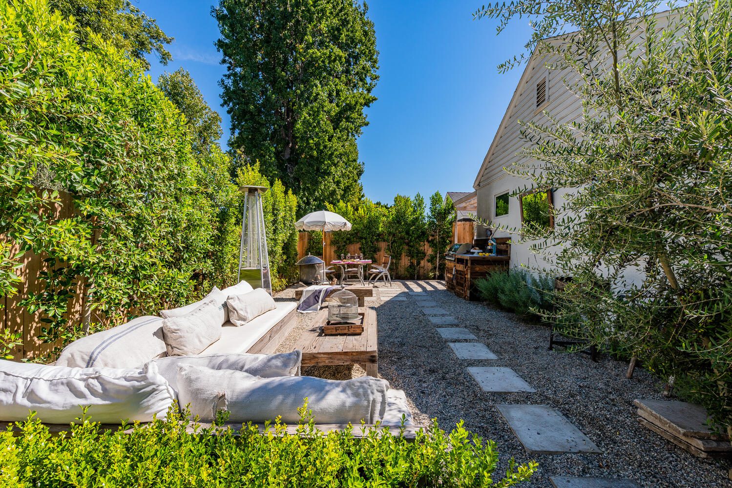 A patio with furniture and trees in the background.